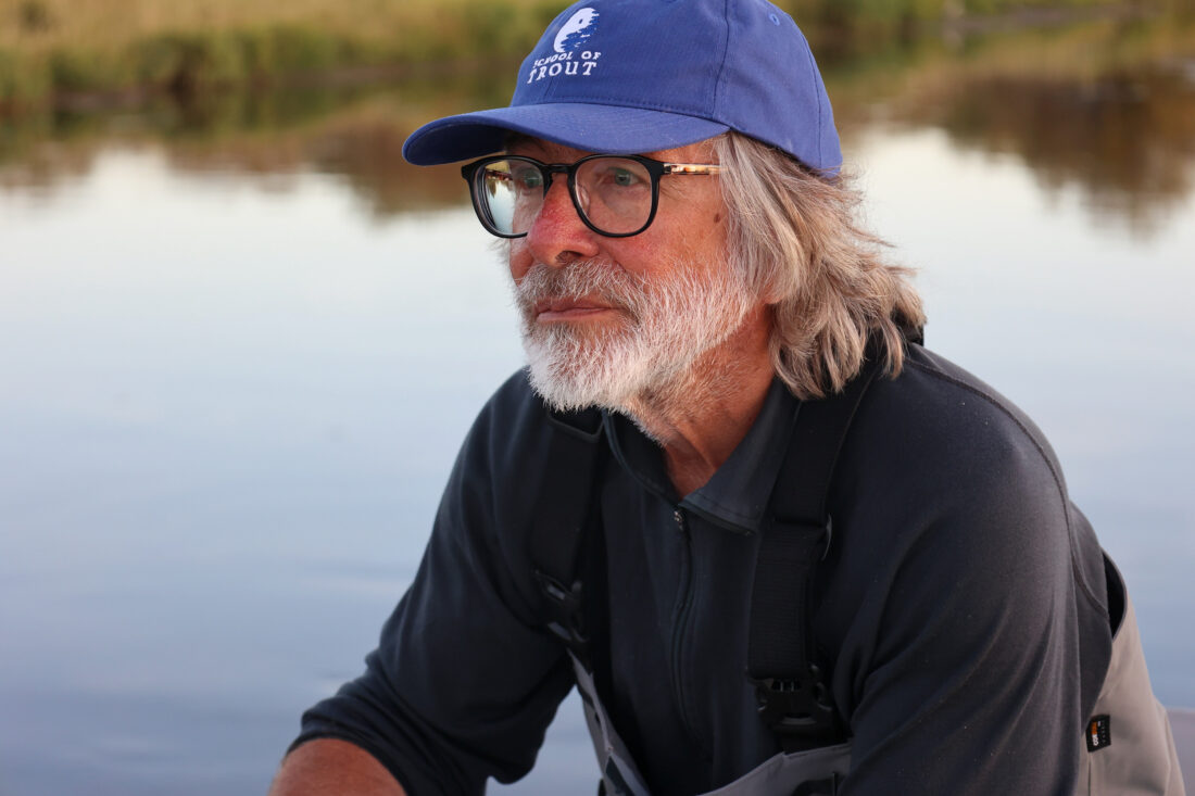 A portrait of a man sitting near a river