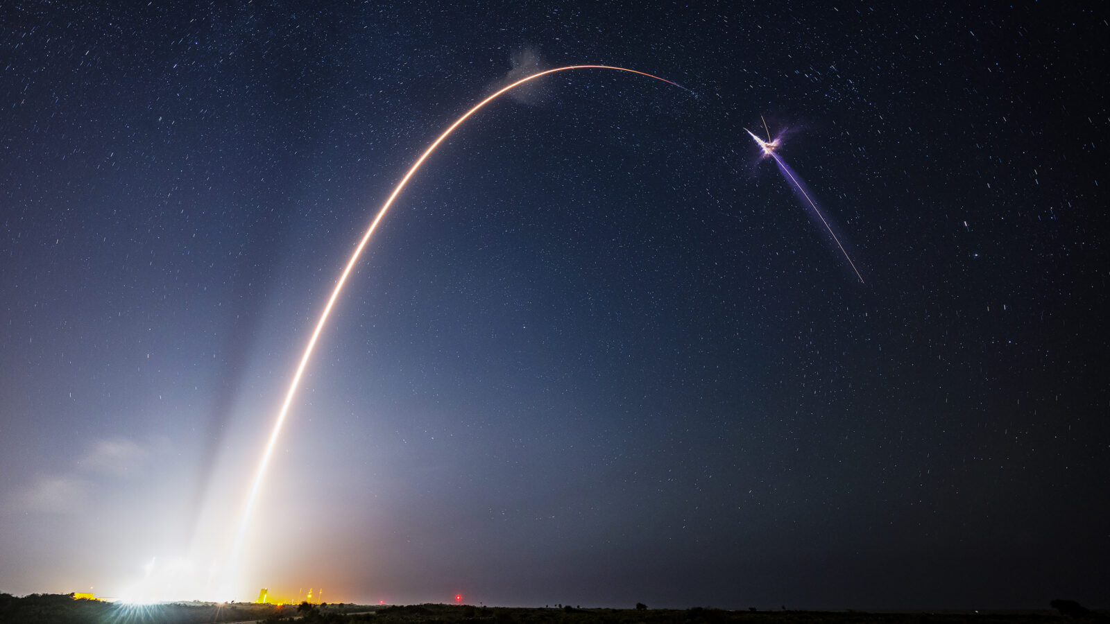A rocket launches into a night sky